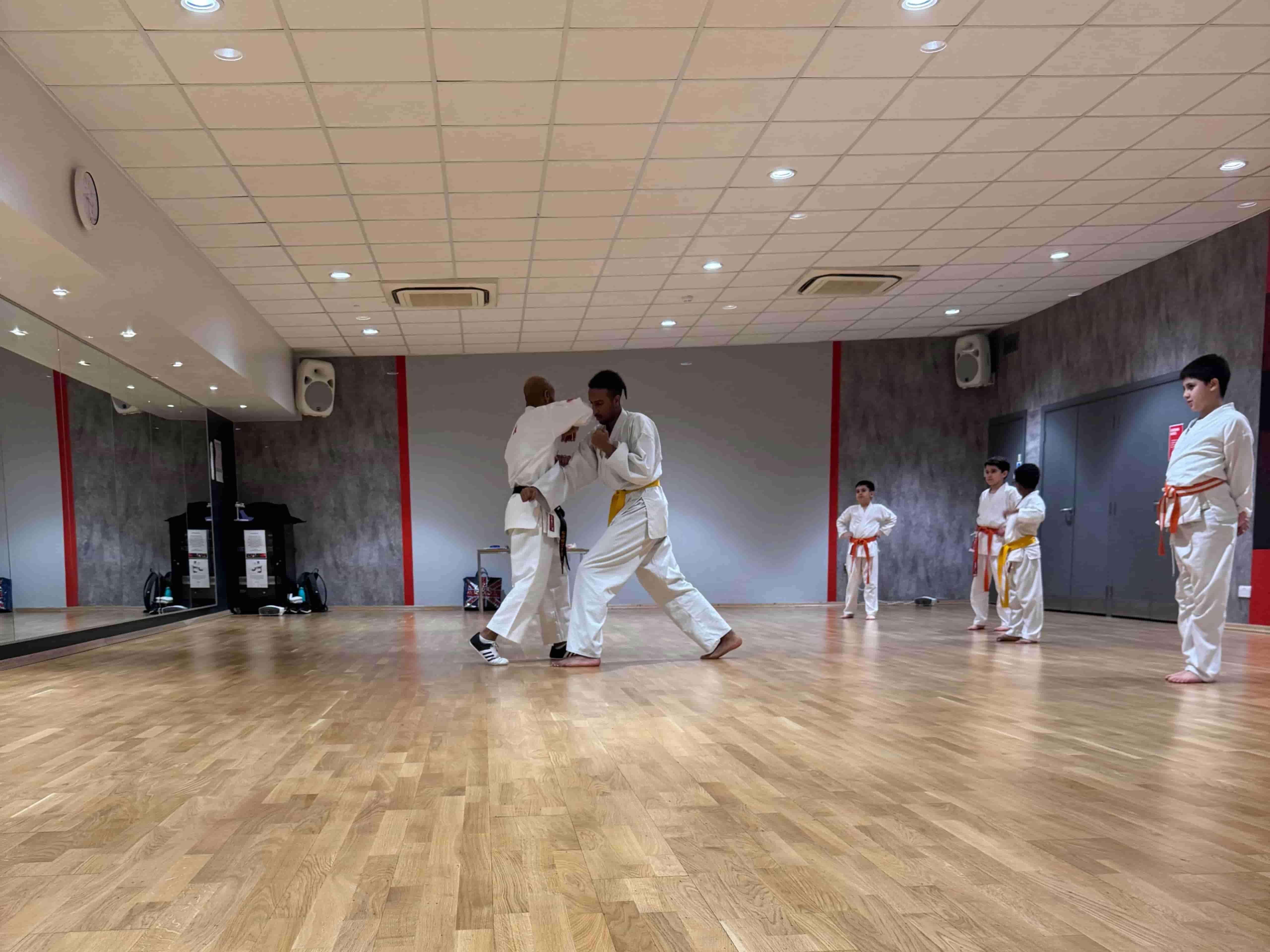 Students practicing Shotokan karate blocks in London dojo