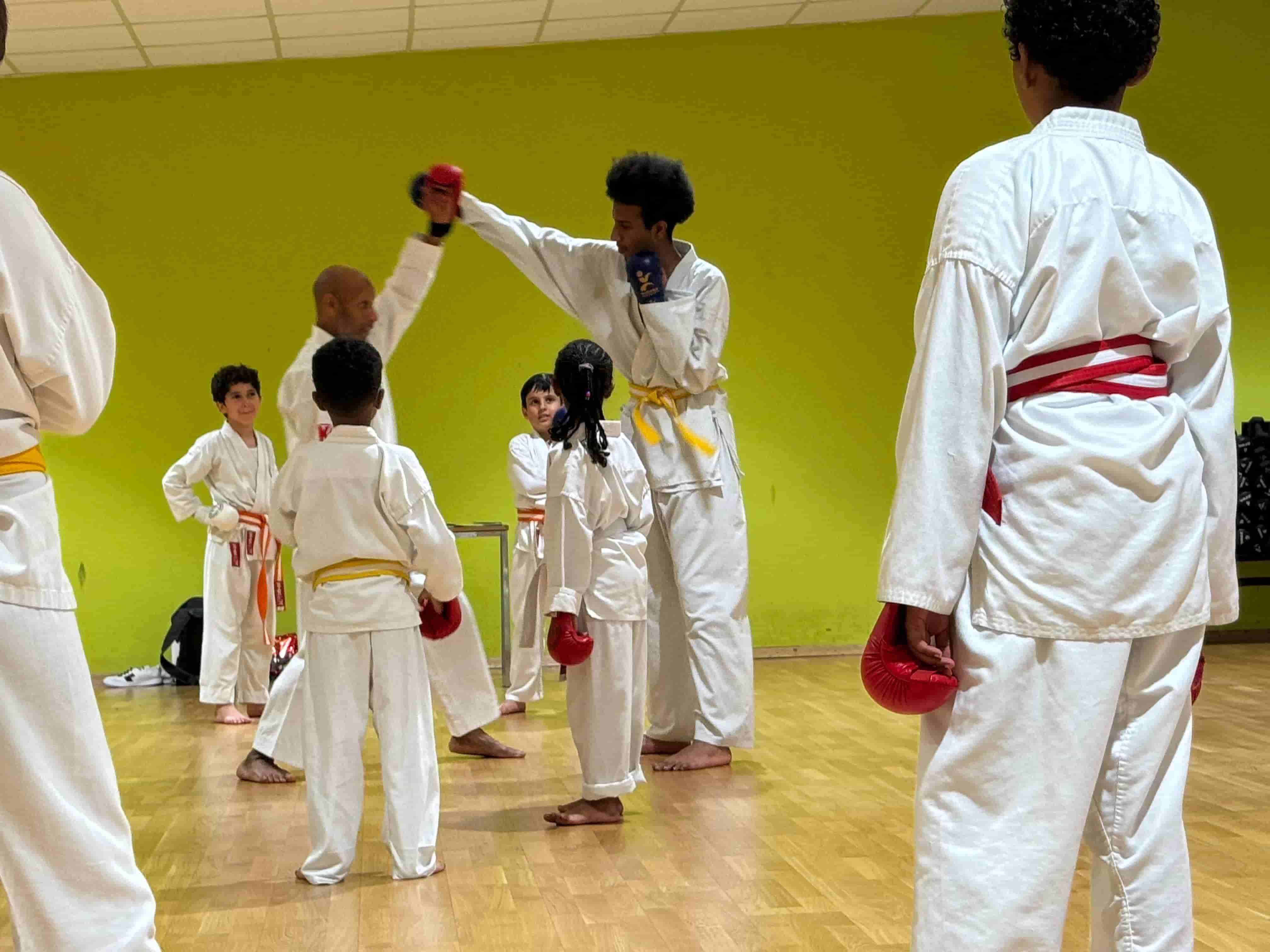 Students practicing Shotokan karate blocks in London dojo