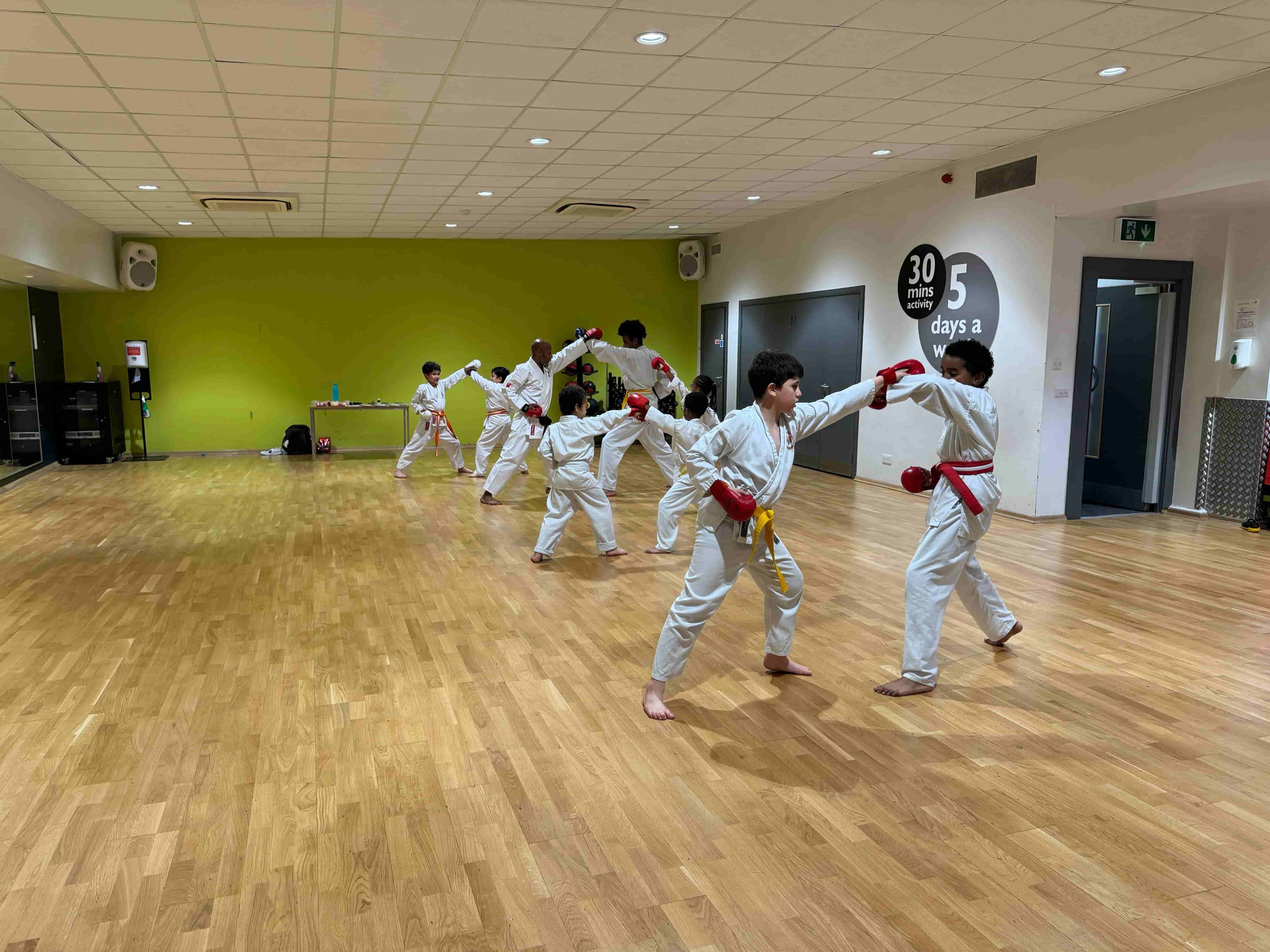Students practicing Shotokan karate blocks in London dojo